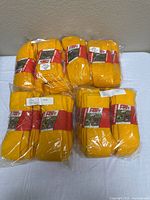 Six sealed bundles of gold Pro Feet socks on table