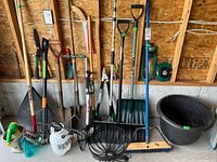 Group shot of all long-handled tools, pump, sprayer, broom, rake head and sprinklers