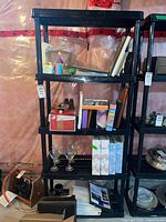 Full view of black plastic shelving unit with five shelves