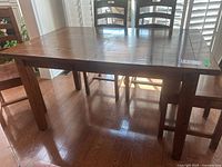 Full view of rectangular reclaimed wood dining table with chairs shown for scale