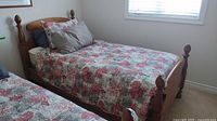 Full view of twin pine bed frame with bedding on mattress
