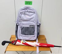 Backpack front and folded umbrella on table