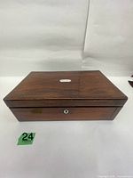 Closed wooden writing slope showing top brass cartouche