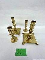 All four brass candlesticks grouped