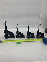 All four embossing presses lined side by side with tape measure for scale