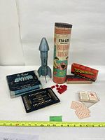 Group shot of Sta-Lox tube, metal rocket, Autobridge box and board, dominoes box, bricks and deal sheets
