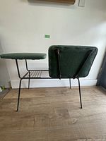 Rear view showing green vinyl seat, tabletop, wire shelf, metal frame
