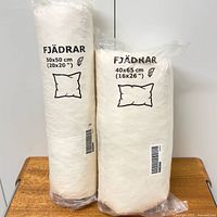 Front view of both sealed pillow inserts showing size labels 50×50 and 40×65 cm
