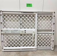 Front view of white plastic pressure-mounted adjustable pet gate