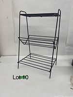 Full view of metal shelf table showing three tiers, overall structure