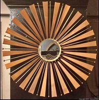Full view of starburst mirror showing wood slats, brass spokes, center mirror
