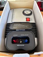 Top view of compressor inside box showing gauge and accessory compartment