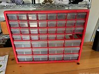 Front view of red Akro-Mils organizer showing clear drawers and missing units