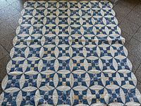 Full view of quilt laid flat showing full pattern and scalloped edges