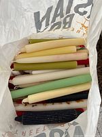 Bag with assorted taper candles in multiple colors