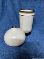 Bud and cylinder vases standing on blue backdrop showing shape and color