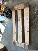 Top view of wooden rolling platform showing three slats and corner reinforcements