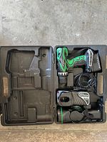 Open carry case showing drill/driver with battery, flashlight, charger, extra battery