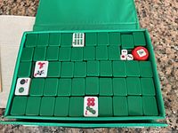 Open case showing engraved Mahjong tiles, dice, wind indicator within fitted tray