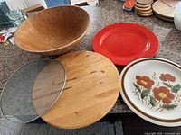 Top view showing wooden bowl, wooden lazy susan, red melamine plate, pottery flower plate, splatter screen, stacked extra lazy susans, small flowered pot