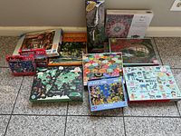 Group view of ten puzzle boxes and tall Springbok puzzle showing brands, piece counts and subjects