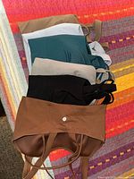 Six stacked Lululemon sports bras showing colors and strappy backs