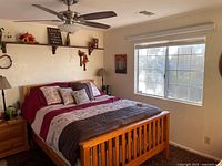 Overall bedroom view showing queen bedframe, nightstand, dresser