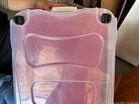 Clear lid showing molded recesses and two wheels