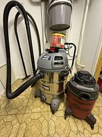 Both Shop-Vac units with hoses and accessories visible