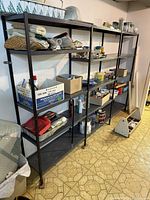 Three grey metal shelving units side by side, contents not included
