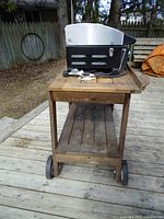 Grill on wooden cart viewed from front left