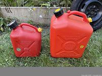 Front view of both red fuel cans showing size difference and caps