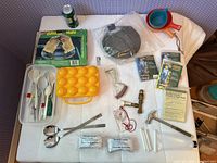 Overall view of assorted camping items laid out on white surface