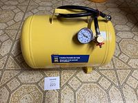 Overall view of yellow 5-gallon Power Fist portable air tank with gauge and hose