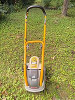 Front view of Ryobi electric cultivator showing handle, motor housing marked 12 AMP POWER, and tines area