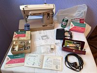 Overall view of Singer 404 machine, pedal, manuals, attachments, dust cover