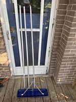 Snow rake assembled showing three aluminum sections with blue head