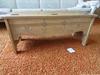 Front view of bench showing carvings and legs