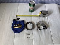 Blue drawstring pouch, pot support ring, folded backpacking stove, scale items