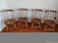Front view of four matching spindle back wooden chairs
