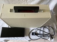 Top view of sewing machine inside carry case with foot pedal and cord alongside