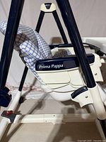 Side view of Peg-Perego Prima Pappa high chair showing frame, seat, tray and label