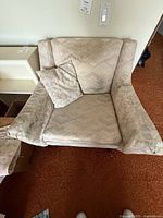 Front view of teak armchair with pillow and armrest covers visible