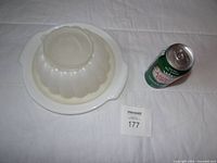 Jelly mold assembled on platter beside soda can for scale