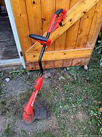 Full view of Black & Decker GrassHog trimmer leaning against shed