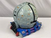 Exterior view of closed spherical TMNT Technodrome playset with geometric paneling and orange window details on grey, blue and purple base.