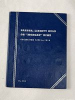 Blue coin collection folder for Barber, Liberty Head, or Morgan dimes dated 1892-1916 with white lettering on cover.