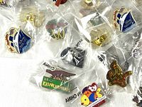 Close-up photo showing a selection of McDonald's collectible pins in plastic wrappers featuring logos and characters.