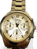Front close-up showing the gold tone dial with subdials and Guess branding.