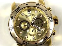 Close-up front view of the Invicta Pro Diver gold tone chronograph watch face without wristband, showing luminous hour markers, three subdials, and date window.